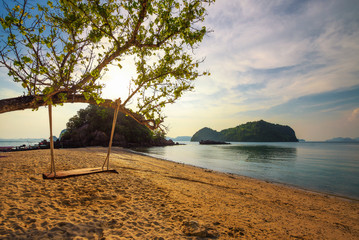 Empty swing at a beach in Thailand at sunset