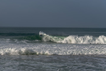 Atlantic wave and surfer, Nazare, Portugal.