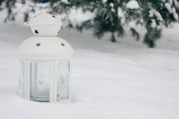 white lantern on the snow against snow-covered branches.Beautiful winter background, copy space