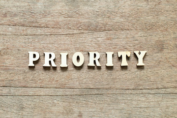 Letter block in word priority on wood background