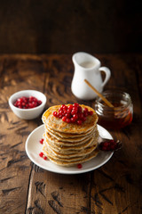 Pancakes with red berries and honey