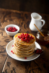 Pancakes with red berries and honey