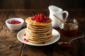 Pancakes with red berries and honey