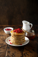 Pancakes with red berries and honey