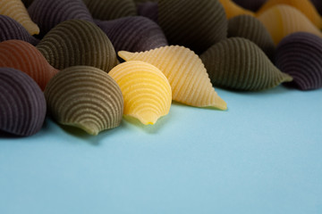 Conchiglie Rigate pasta shells closeup  on  blue background with copy space