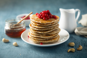 Pancakes with red berries and honey