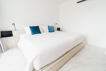 A white bedroom with a wooden bed, bed linen and a pillow with white cloak. good for relaxing The white room makes the room feel comfortable.