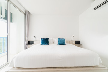A white bedroom with a wooden bed, bed linen and a pillow with white cloak. good for relaxing The white room makes the room feel comfortable.
