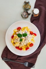 Cooked pasta with a cream sauce and roasted chicken cured with emmental..