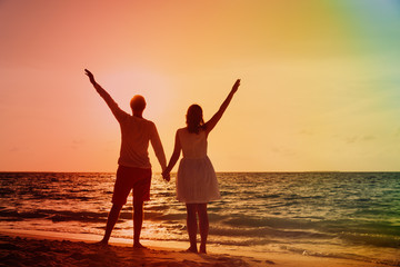 Happy romantic couple on the beach at sunset