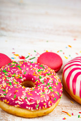 Donuts and macaroons on a wooden background.