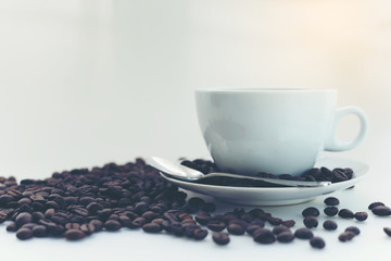 Coffee cup and coffee beans soft focus on white background