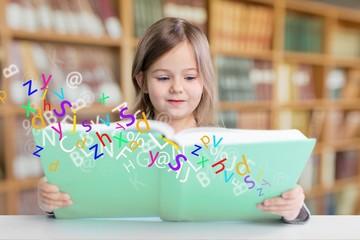 Adorable young girl reading a book