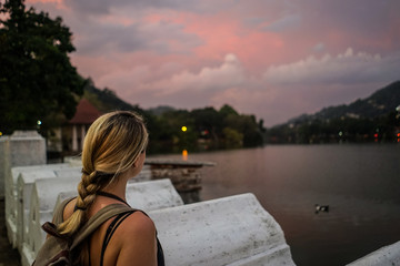 girl with plait looking out at lake at sunset