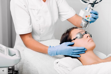 woman getting laser facial treatment, aesthetic surgery,
