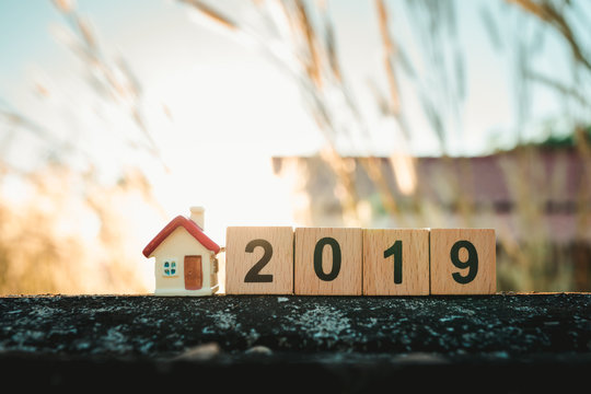 Miniature house with wooden block year 2019 on sunset using as family and property concept