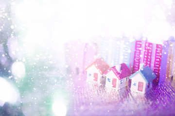 miniature house with blue roof on blurred Christmas decoration background.Image for property real estate investment concept