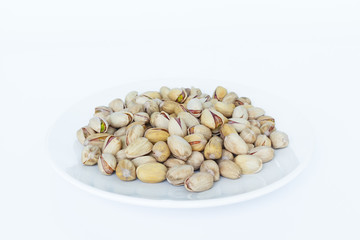 pistachio in plate on white background.