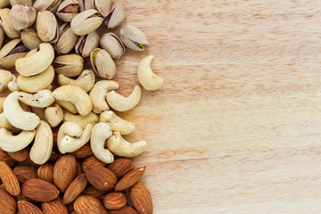 mix almond and pistachio and cashew on wooden background