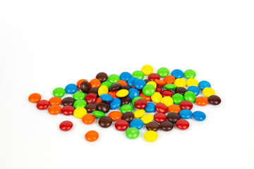 Colorful chocolate M&Ms in and out of focus on white background