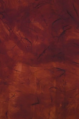 Old textural wall of dark red color cracked by time and weather conditions