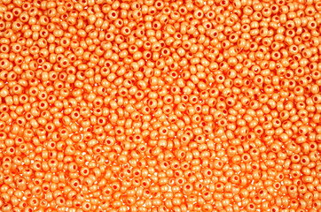 Flame-orange glass beads background - closeup beads texture