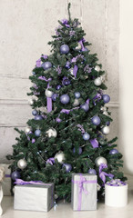 Fototapeta na wymiar New Year tree decorated with violet and shiny toys