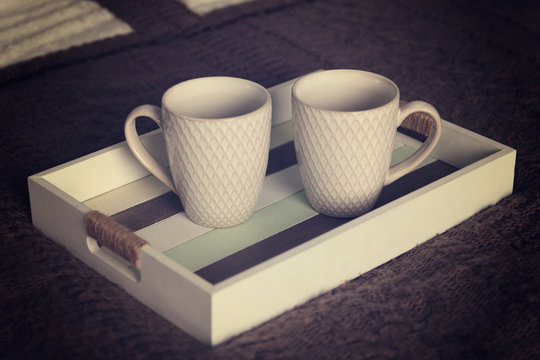 Two porcelain cups lie on a tray