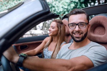 close up.stylish man with his girlfriend traveling in a convertible car.