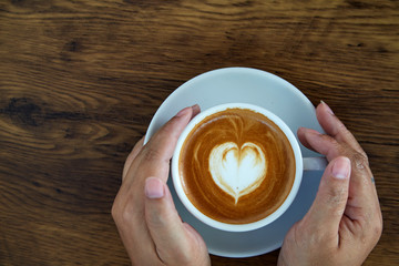 Hands holding coffee cup heart cup