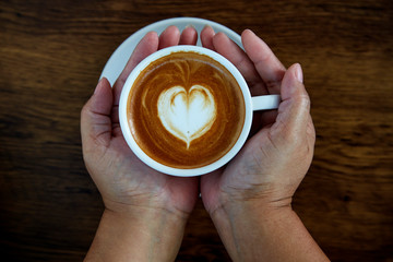 Hands holding coffee cup heart cup