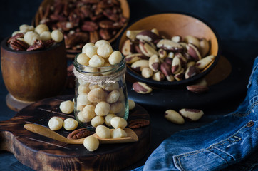 Variety of nuts: macadamia, pecan and brazil nuts in rustic style