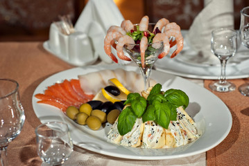 Delicious dishes on the table in the restaurant. serving table. Marine dishes. Fish and squid dishes on a plate.