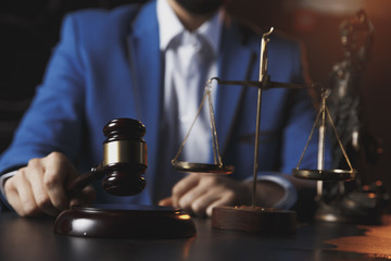 justice and law concept.Male lawyer in the office with brass scale on wooden table,reflected