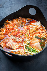 Traditional Korean kimchi jjigae with grilled pork belly and ramen as closeup in a modern design...
