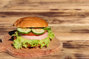 Fresh delicious homemade burger on wooden table