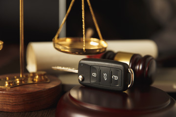 Close up of judge gavel and car keys over soundboard