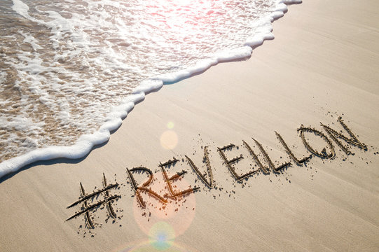 Message for Reveillon (a French word for awakening that represents New Year's Eve in Brazil) written in the sand with a social media hashtag on the beach in Copacabana, Rio de Janeiro
