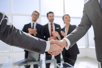 business handshake over blurry background office