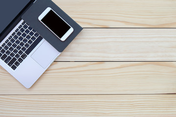 Wood office desk table with laptop open screen, smartphone, and notebook. Top view with copy space, flat lay show device and equipment.