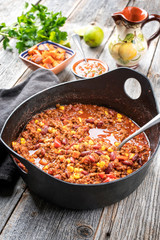 Traditionelles mexikanisches Slow Cook Chili con Cane mit Hackfleisch, Bohnen und  Mais als Draufsicht in einem Modern Design Gußtopf