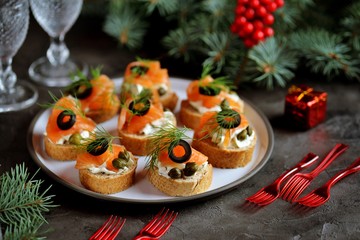 Canapes with cream cheese, salted salmon, capers, olives and dill.