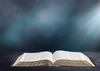 Open book on old wooden table.