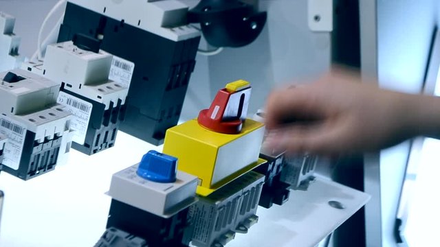 Person clicks pushing on the control panel buttons and pressing the lever close-up. Person tilts the lever to turn it on oa turn off. Control buttons panel close-up.