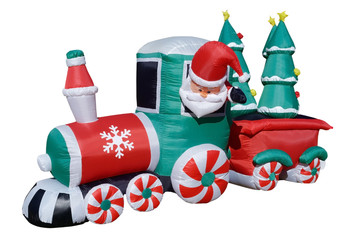 Isolated inflatable Santa train lawn decoration delivering Christmas trees.