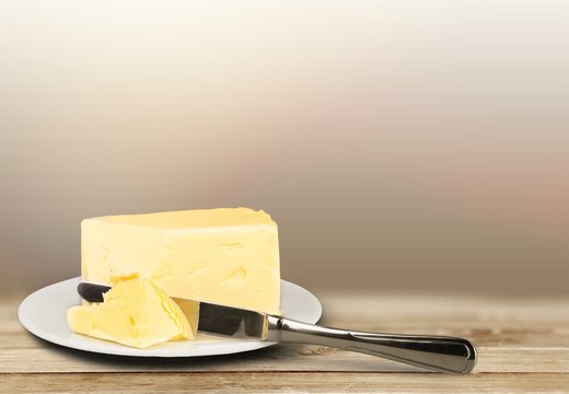 Pat of fresh farm butter on a butter dish with a knife on