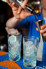 Bartender is stirring cocktails on bar counter
