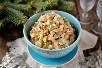 Traditional Russian salad Olivier on an old wooden background. Russian kitchen. Rustic style.