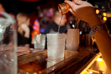 Fototapeta na wymiar Bartender is stirring cocktails on bar counter