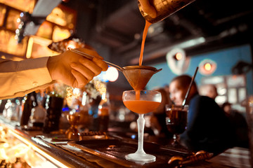 Bartender is stirring cocktails on bar counter